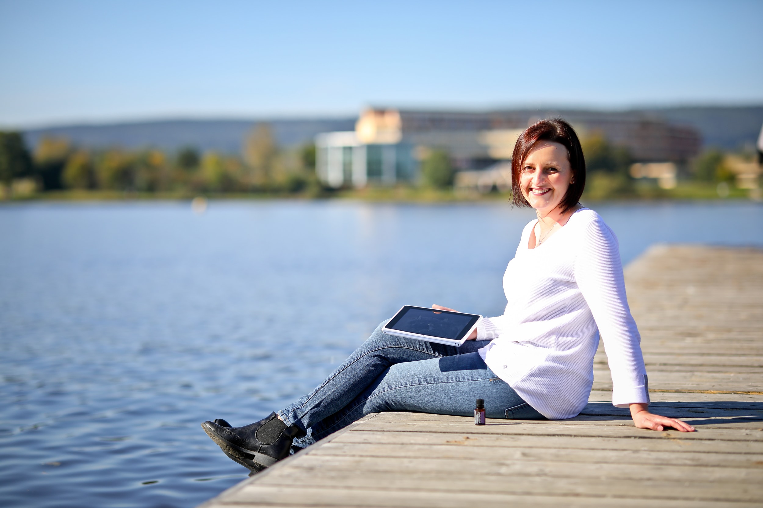 Jessy Richter sitzend am Steg, Weißenstädter See, mit Tablet in der Hand