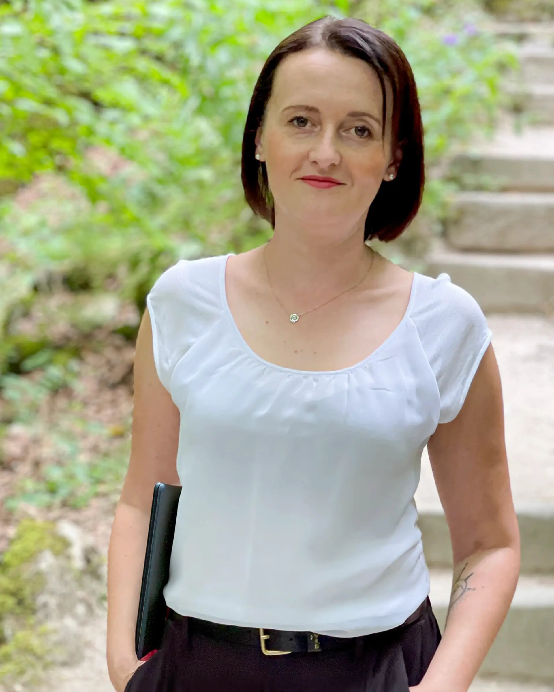 Jessy_Richter_Business_hoch Jessy Richter mit MacBook Air unter dem Arm, stehend in der Natur